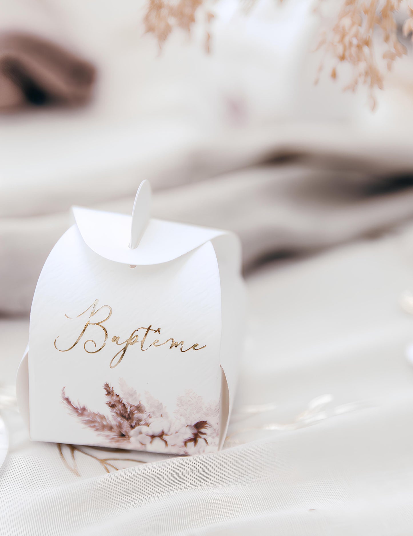 Gros plan sur l'inscription dorée du contenant baptême pampas et fleurs de coton
