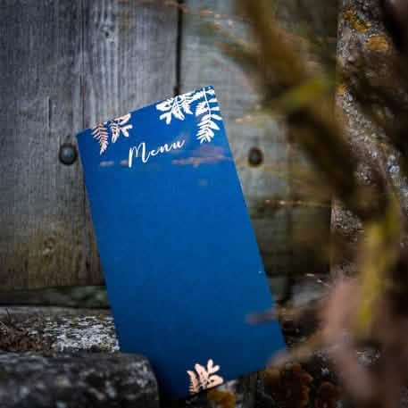 Vue de face du menu fougères pour mariage bleu marine et cuivre