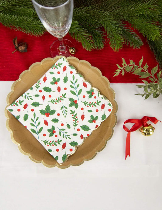 Mise en situation sur une table de fête des serviettes en papier festonnées houx pour Noël