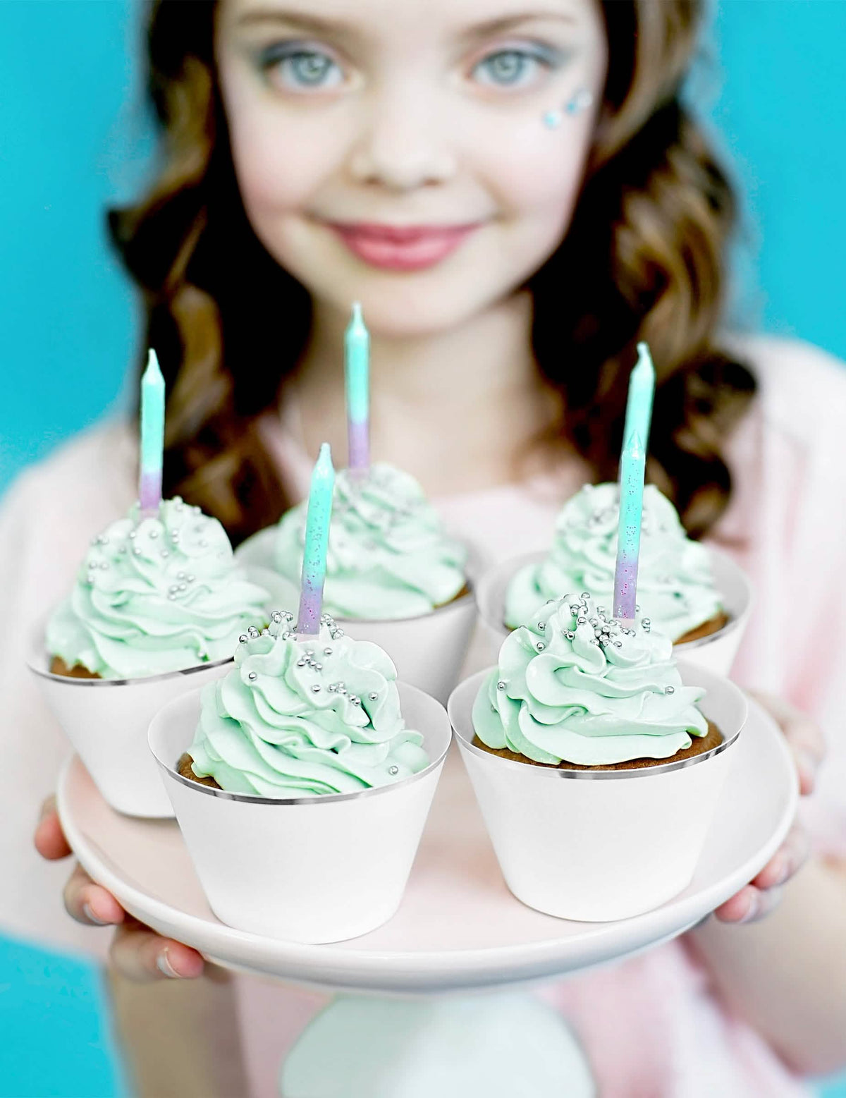 Záber na cupcakes s iridescentnými narodeninovými sviečkami