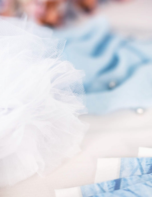 Gros plan sur la texture des pompons à suspendre en tulle pour décoration blancs