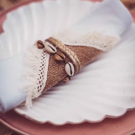 Zoom sur la toile de jute et la dentelle du ronds de serviettes décor marin coquillages naturels et dorés