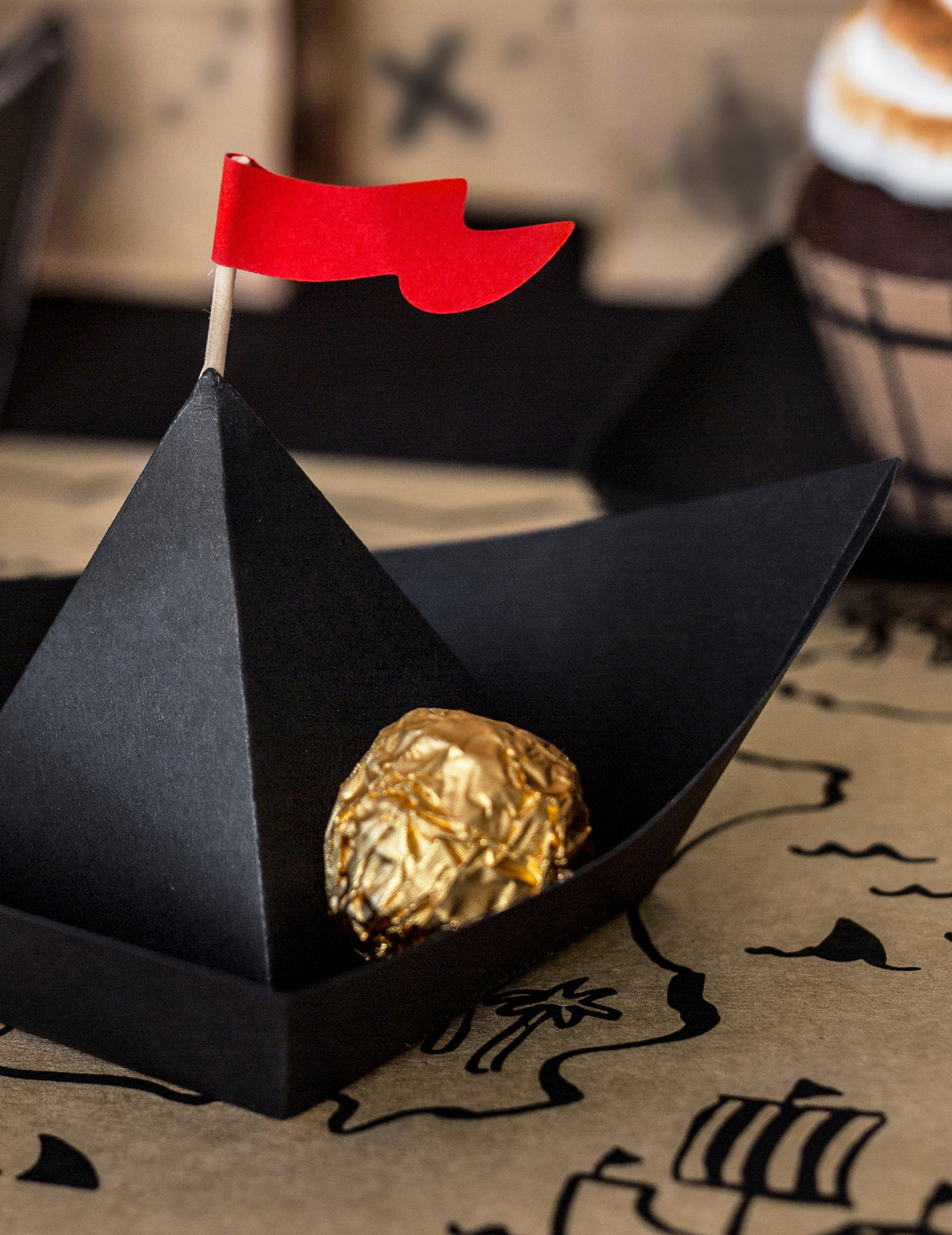 Zlatá čokoláda umiestnená vo vnútri papierovej pirátskej lode origami pirát