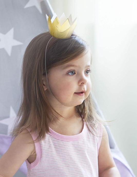 Vue portée par un enfant des 6 mini couronnes dorées pour fête en carton brillant
