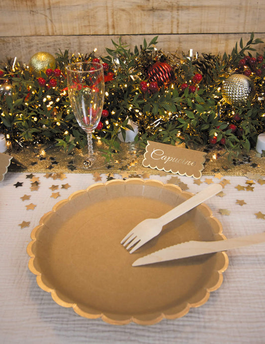 Mise en situation sur une table de fête des assiettes en carton festonnées kraft et or