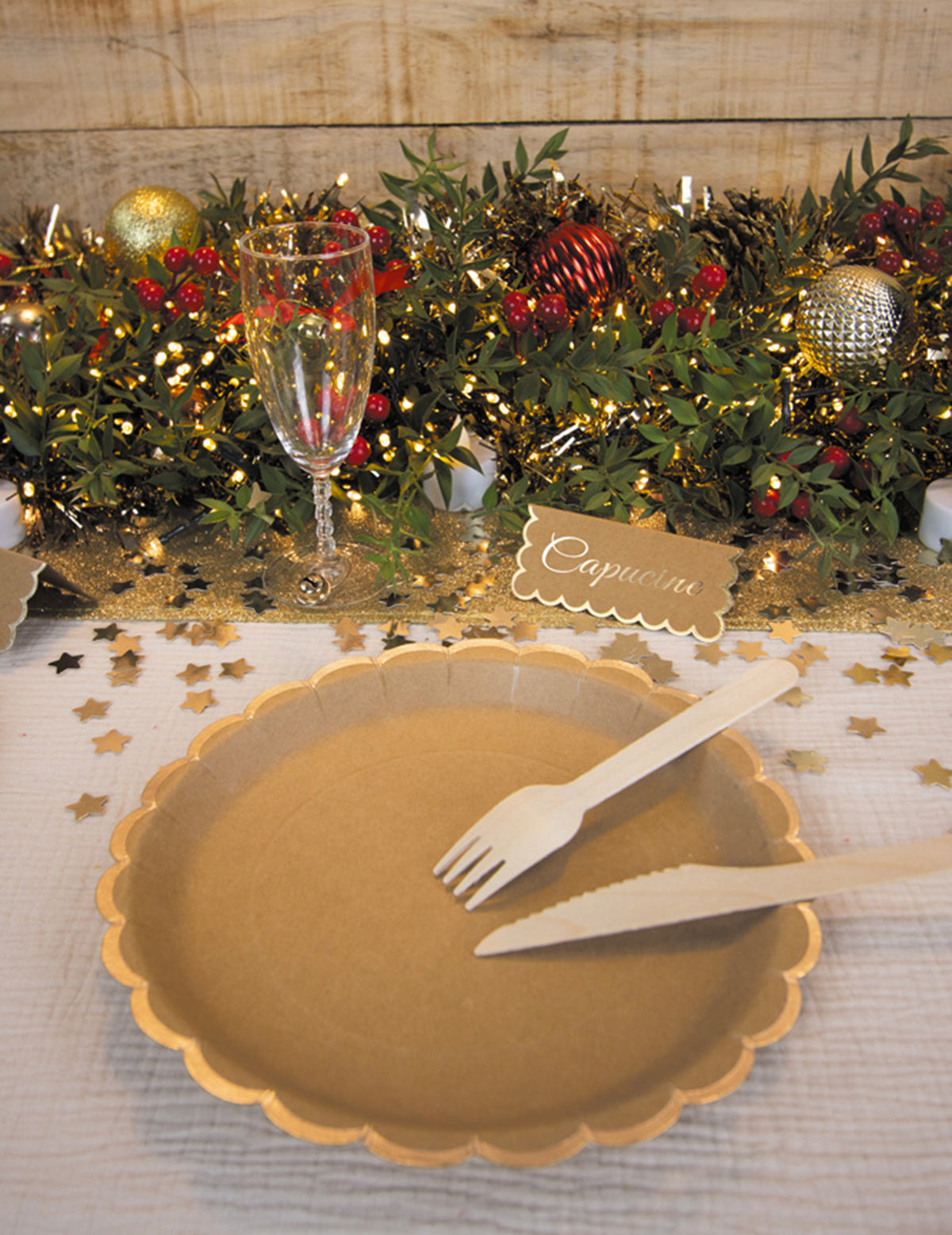 Mise en situation sur une table de fête des assiettes en carton festonnées kraft et or