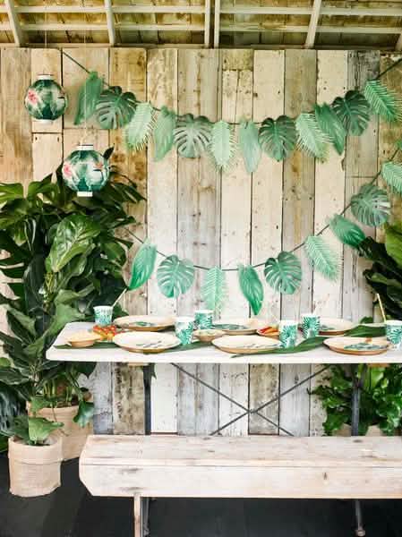 Mise en situation sur une table des gobelets en carton tropical vert avec motifs feuilles de palmier
