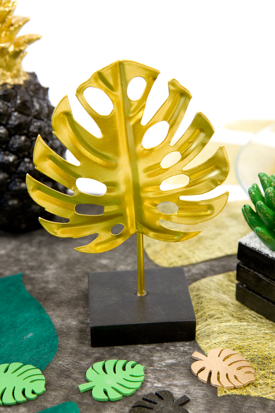 Mise en situation de la décoration en métal sur socle feuille tropicale