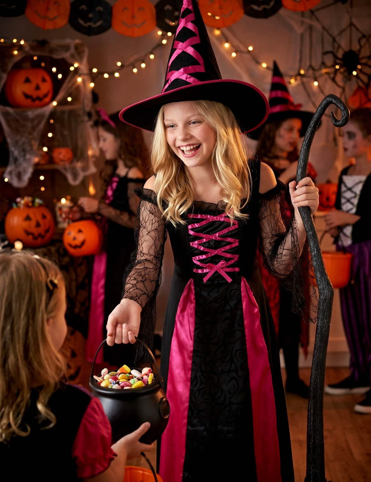 Zinscenovanie s kotlíkom cukríkov k zubatému kostýmu čarodejnice halloween