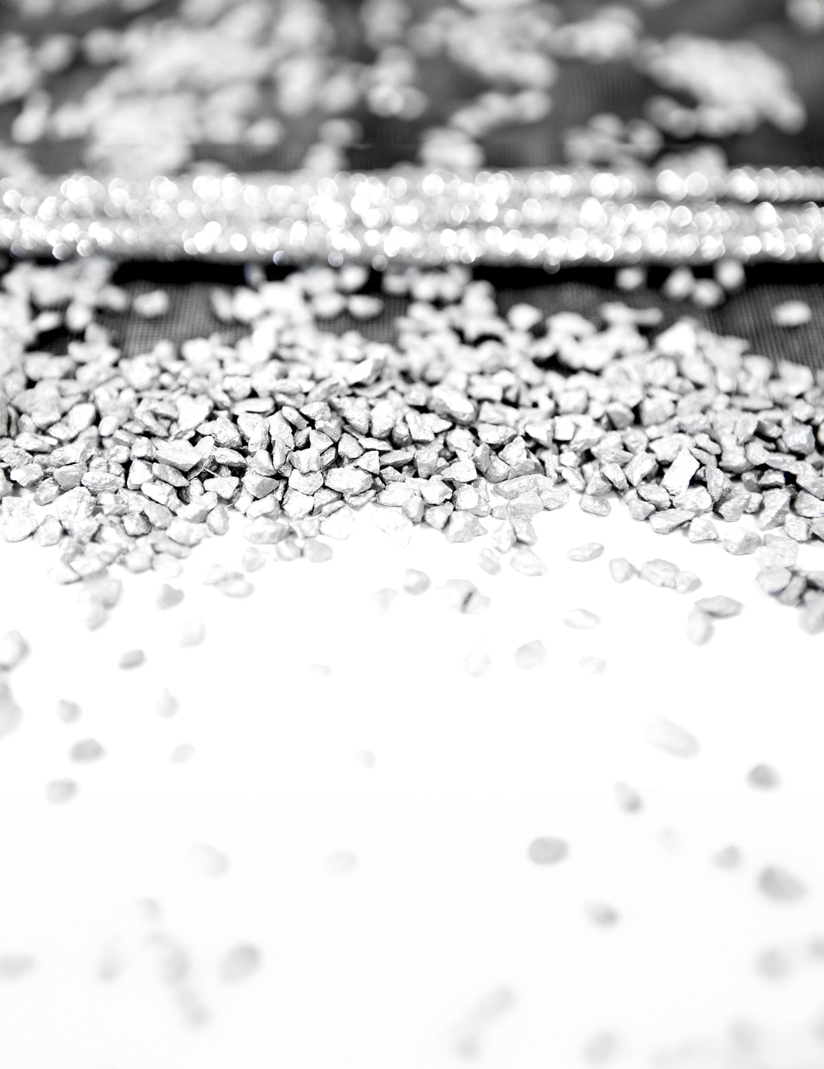Gros plan sur la texture des gravillons argent pour décoration de fête