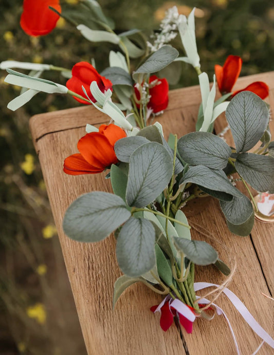 Gros plan sur les fleurs rouges et le feuillage de la guirlande style champêtre