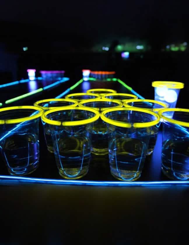 Detailný záber na žlté poháre zo svetelného beer pong setu na párty