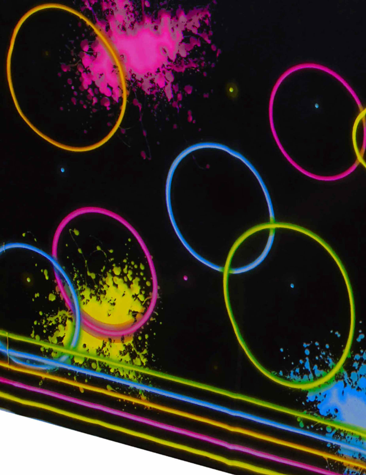 Detail na neónové kruhy a škvrny na čiernom plastovom obrusu Glow Party