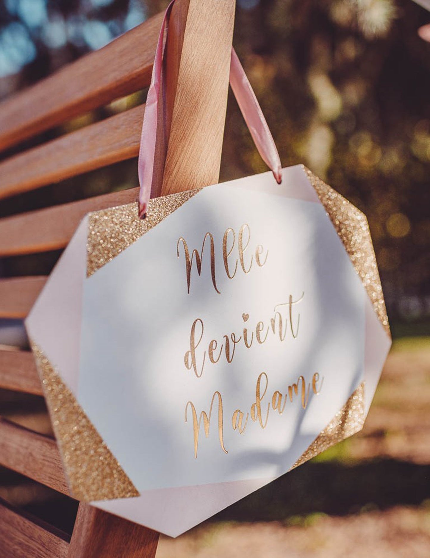 Mise en situation avec ruban rose de la pancarte en carton Mlle devient Madame