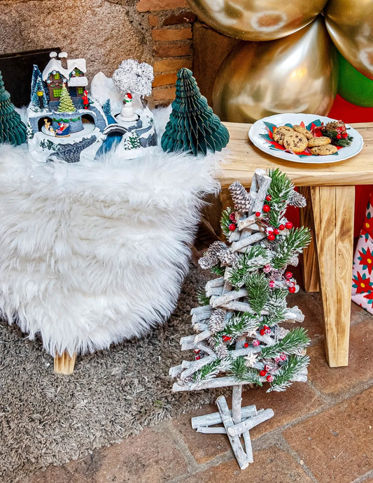 Vue en ambiance du sapin de noël en bois avec baies rouges et pommes de pin