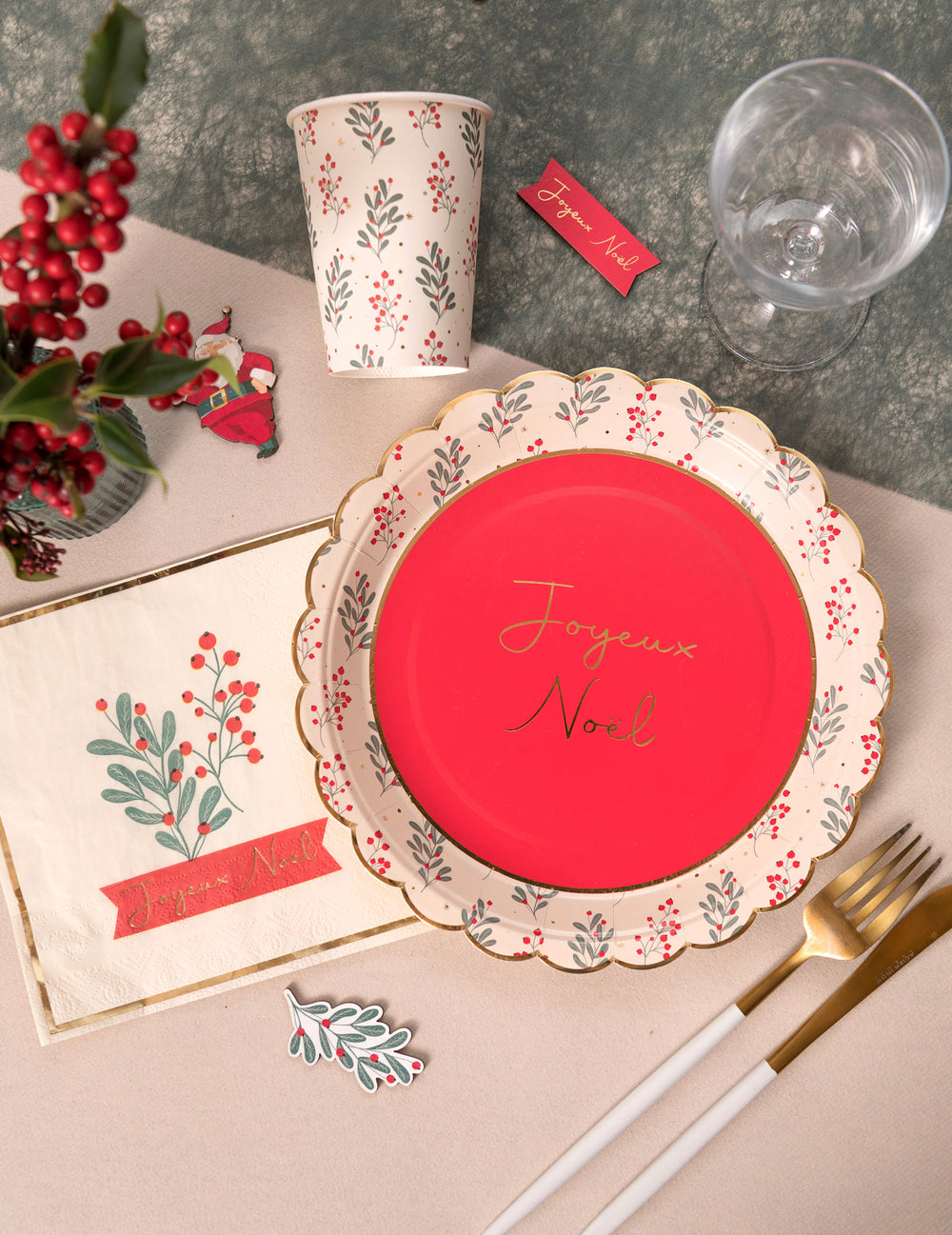 Mise en scène de table des assiettes en carton festonnées houx de Noël Joyeux Noël