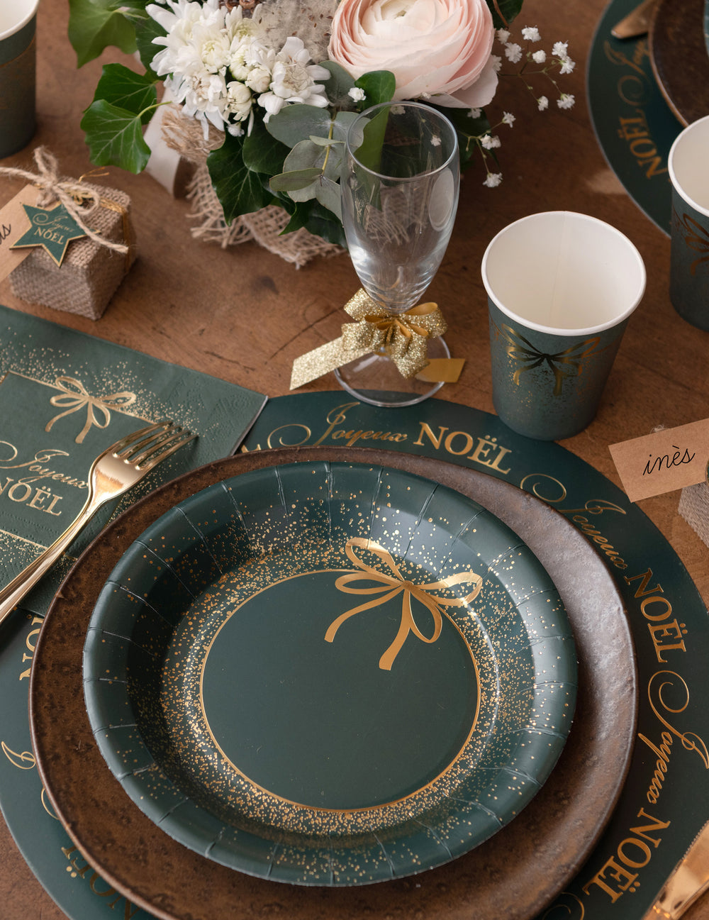 Mise en scène de la table avec les assiettes en carton Noël pour fête vert et doré design chic
