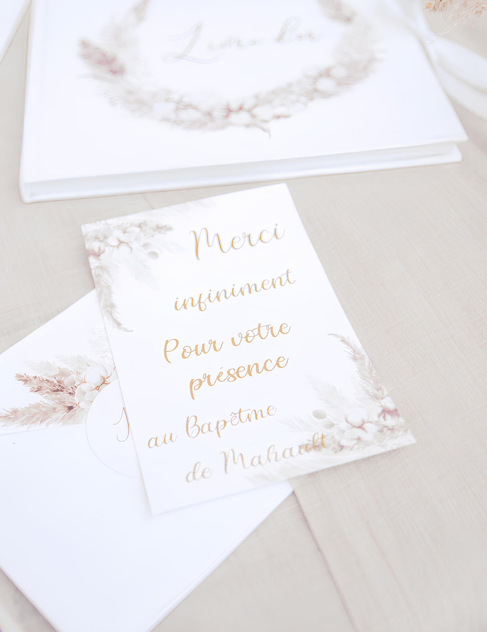 Gros plan sur le texte des invitations avec enveloppes pampas et fleurs de coton