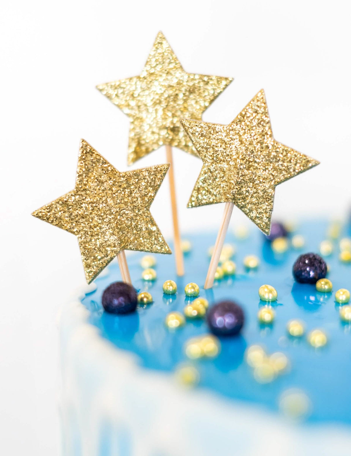 Detail na zlaté trblietky cake toppera na špajli hviezda pre narodeniny