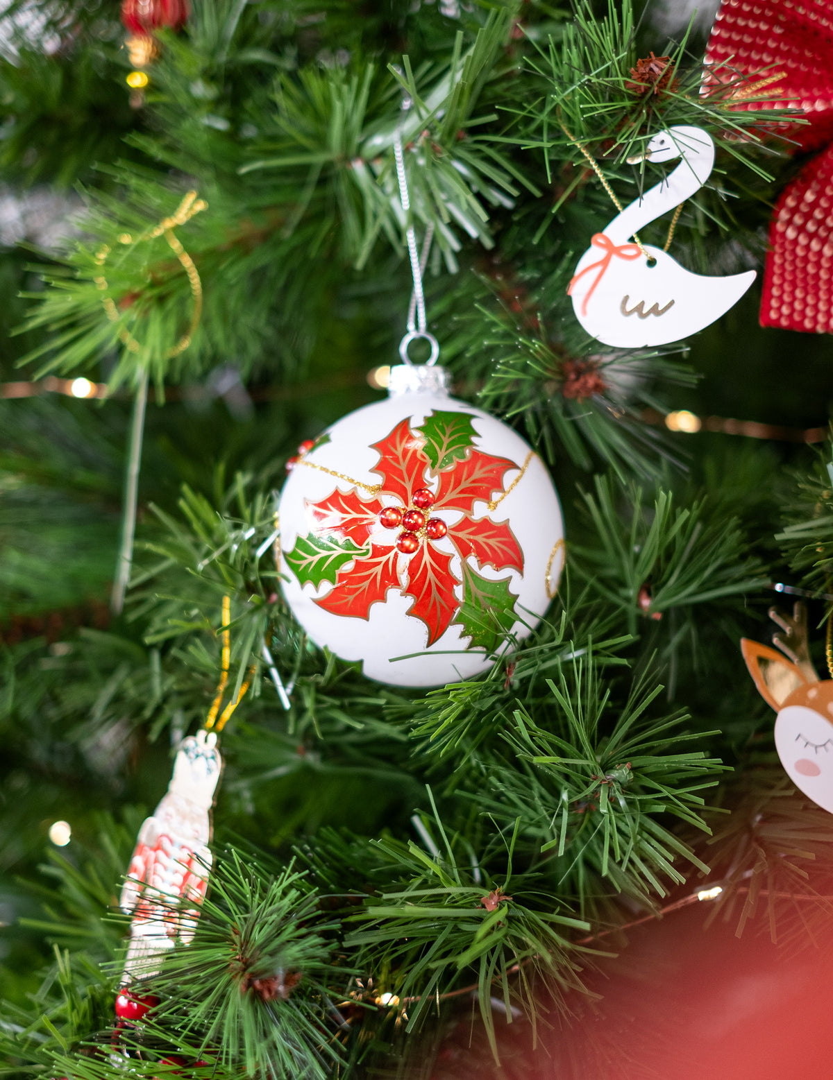 Mise en situation dans le sapin des boules en verre avec houx pour sapin blanches