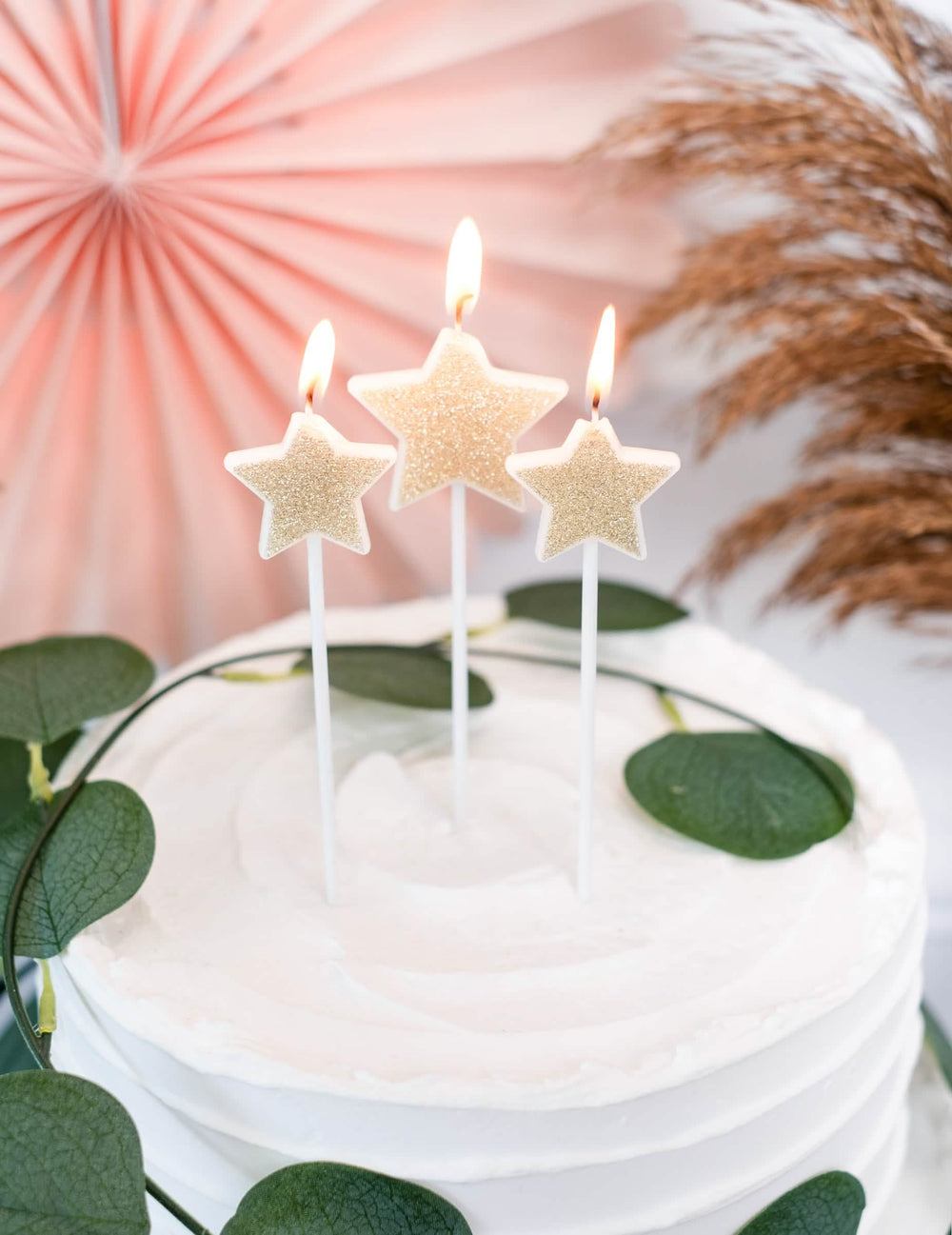 Detail na zapálené sviečky na torte s 3 sviečkami na špajli hviezdy na oslavu