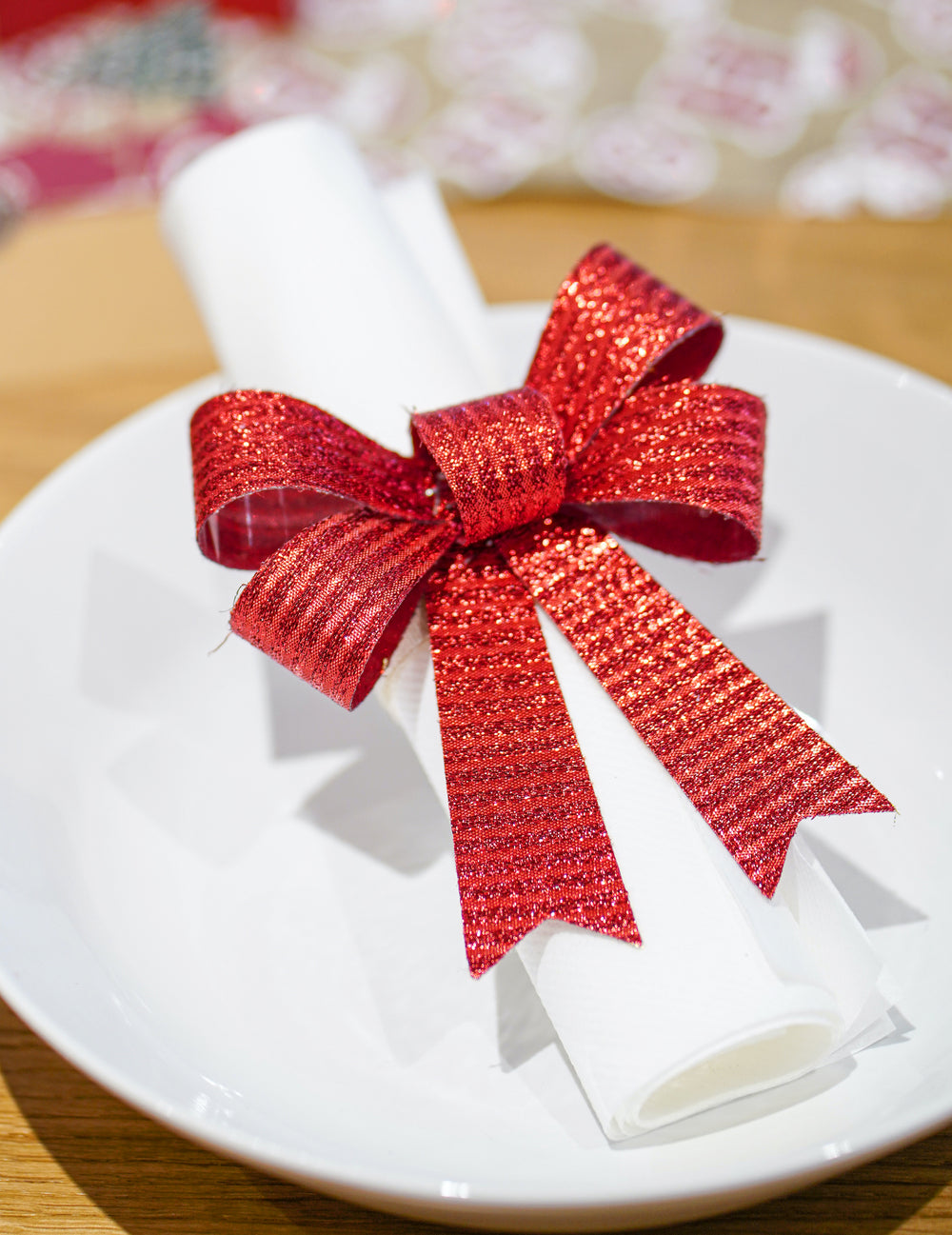 Mise en situation sur une serviette des nœuds pour décoration rouges et brillants
