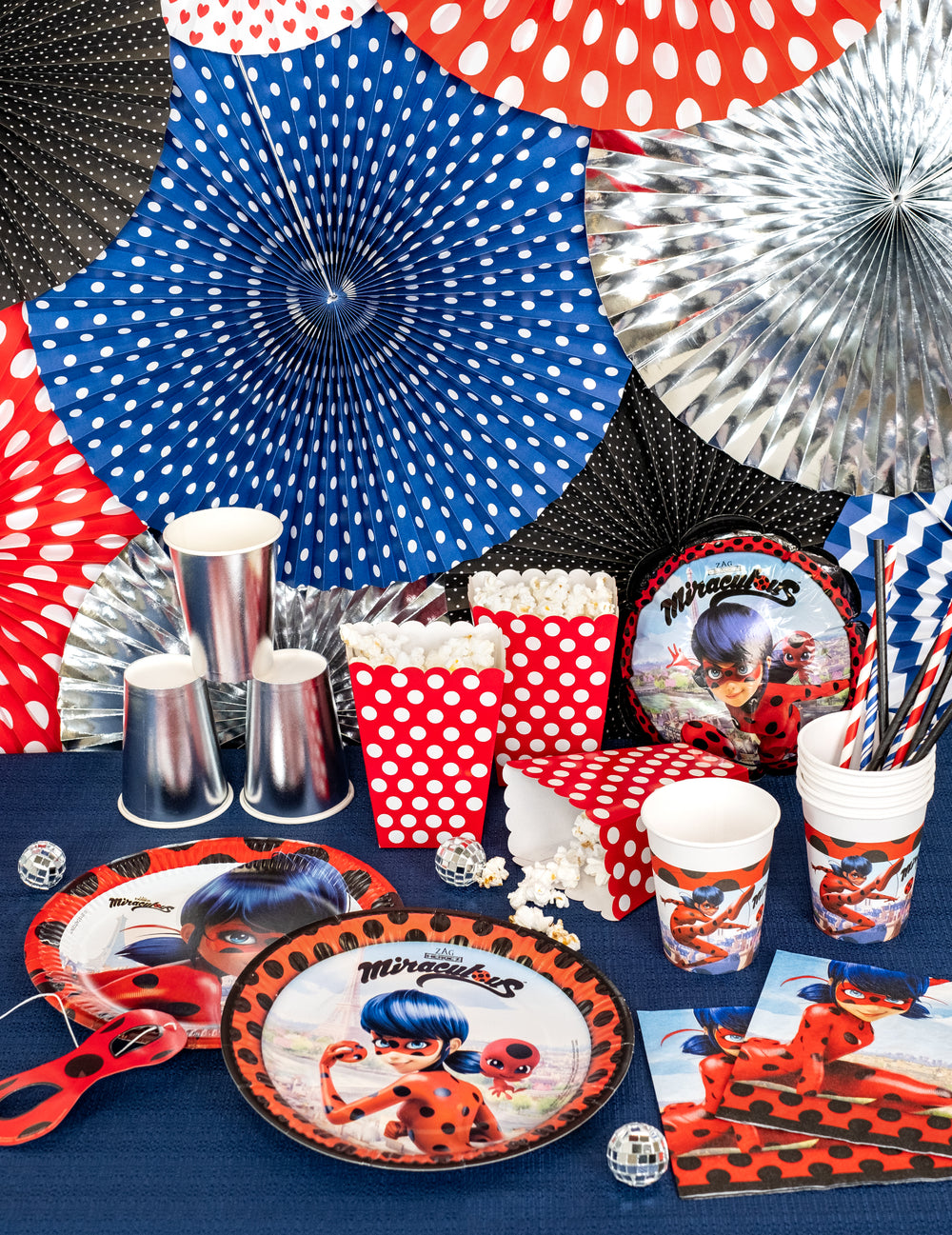 Mise en scène de buffet d'anniversaire Miraculous des 3 rosaces en papier bleu marine à motifs