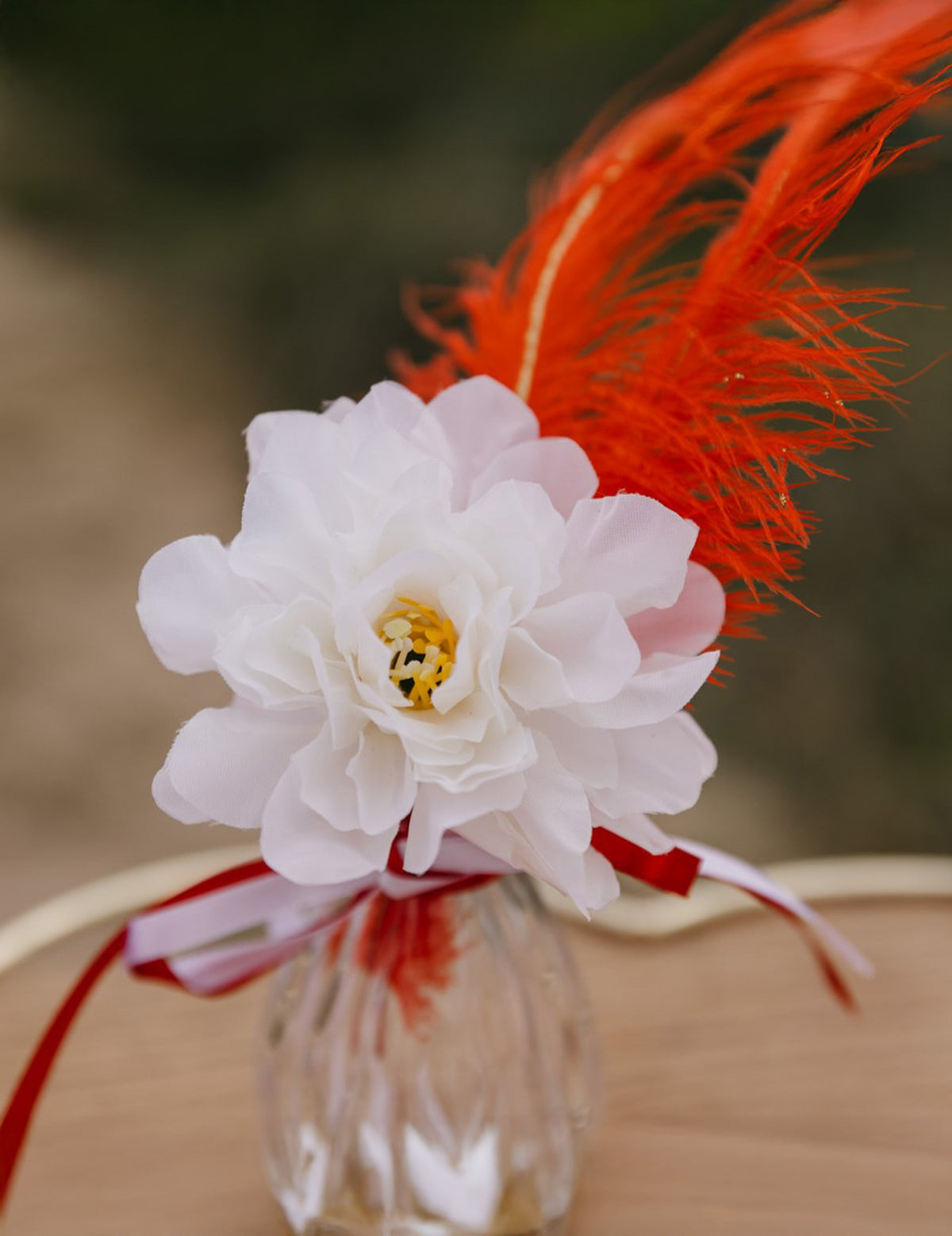 Détail de la plume rouge et du ruban des 4 pivoines pour décoration crème en tissu
