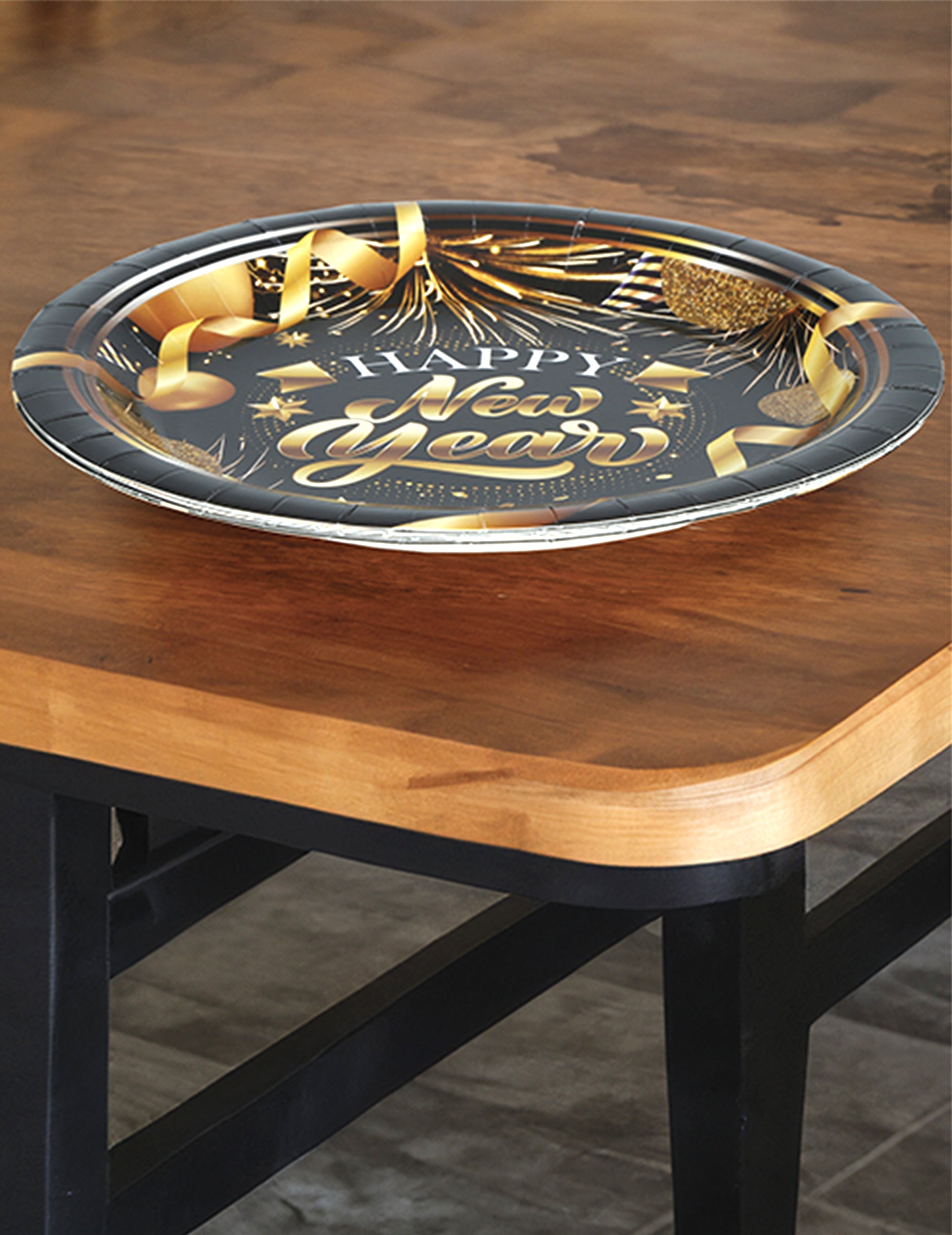 Vue rapprochée sur table des assiettes en carton Happy new year noir et or
