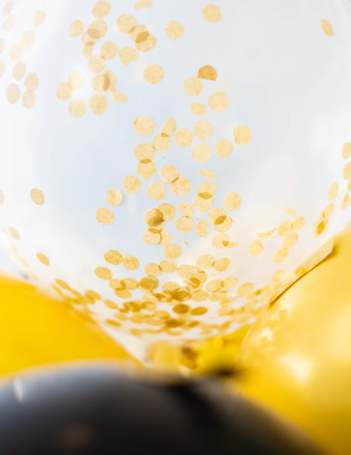 Detail konfety vo vnútri latexových balónov s priehľadnými okrovými zlatými konfety