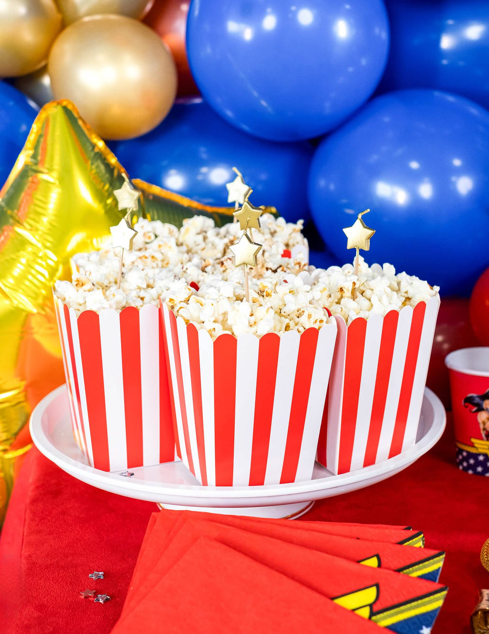 Zinscenovanie v krabičkách na popcorn zo 6 zlatých sviečok na paličke s hviezdami na tortu