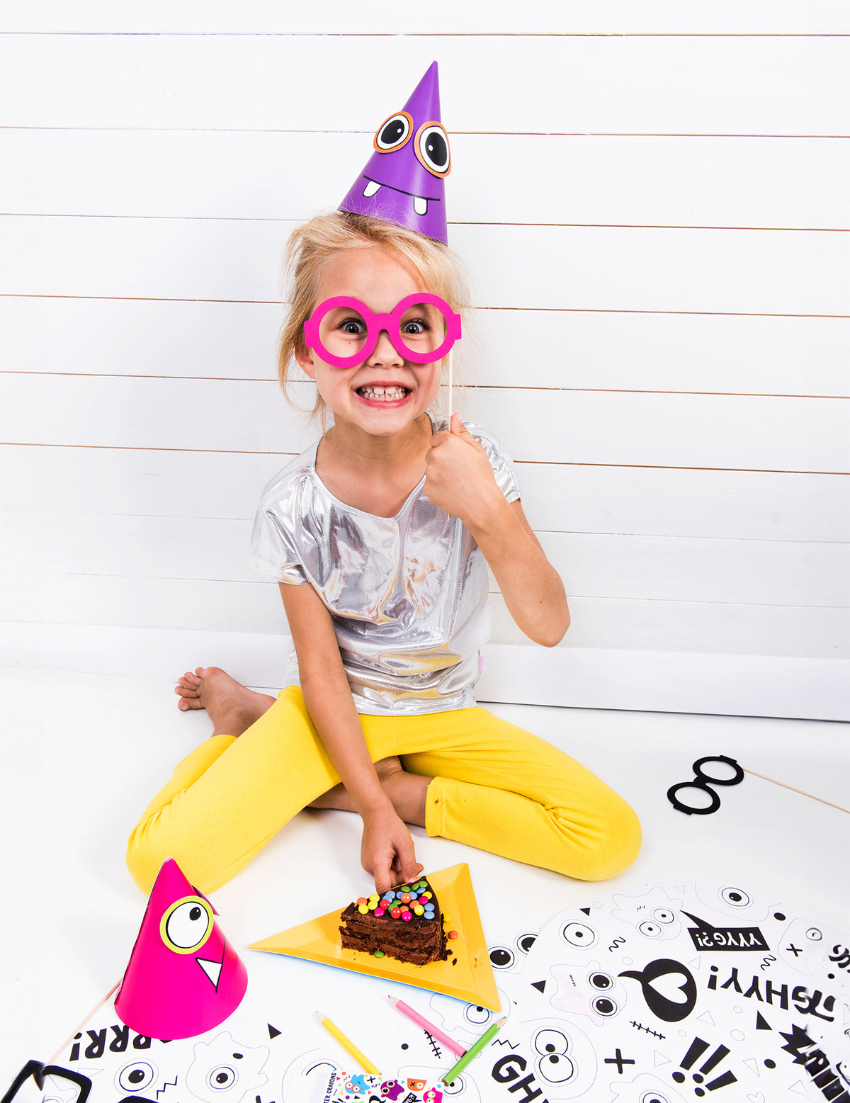 Enfant portant le chapeau violet du chapeaux de fête petits monstres