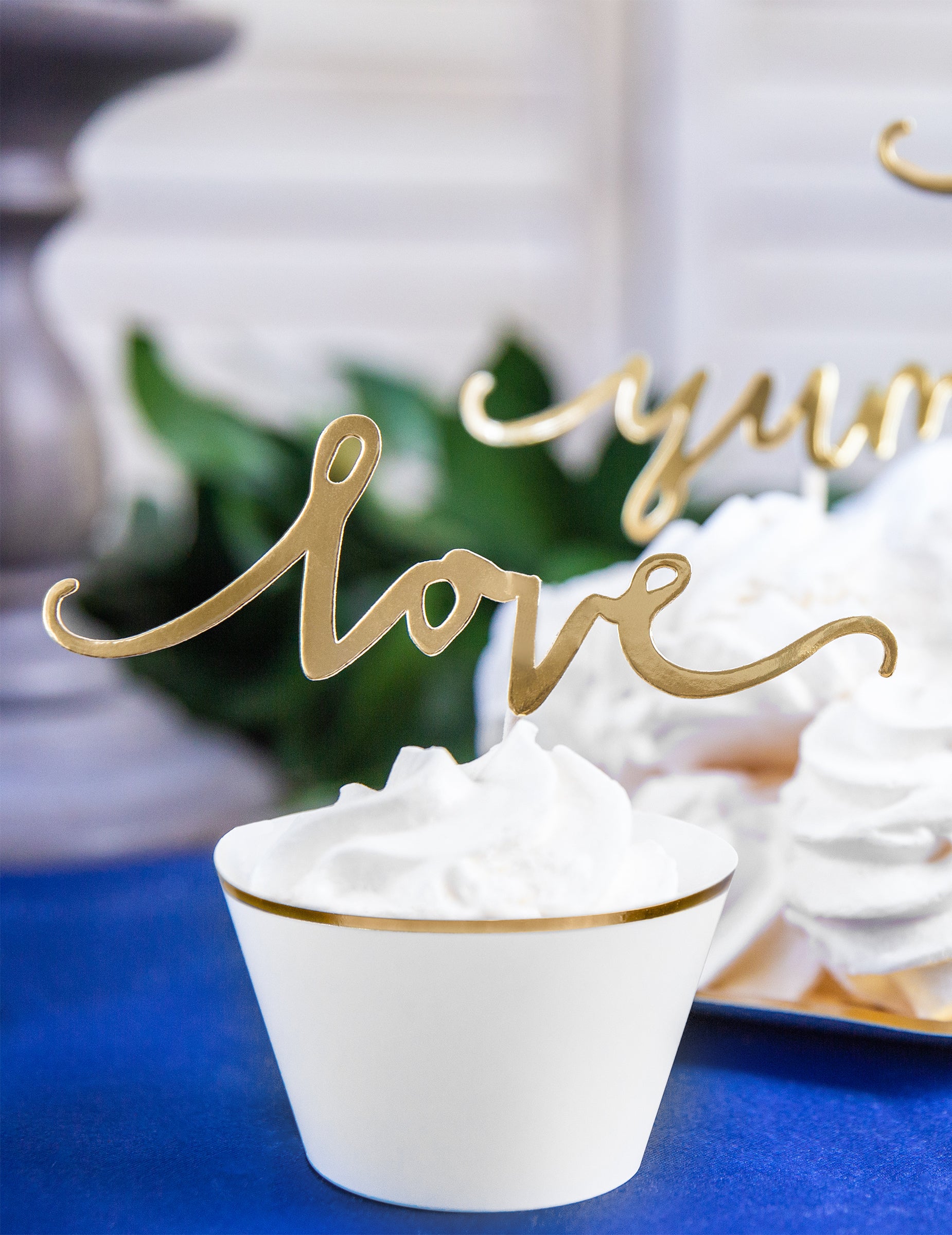 Gros plan sur le cake topper love doré des habillages à cupcakes en papier pour mariage