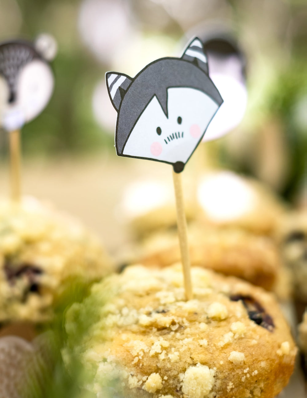 Gros plan sur le pic en bois raton laveur des moules à cupcake et pics en bois animaux de la forêt