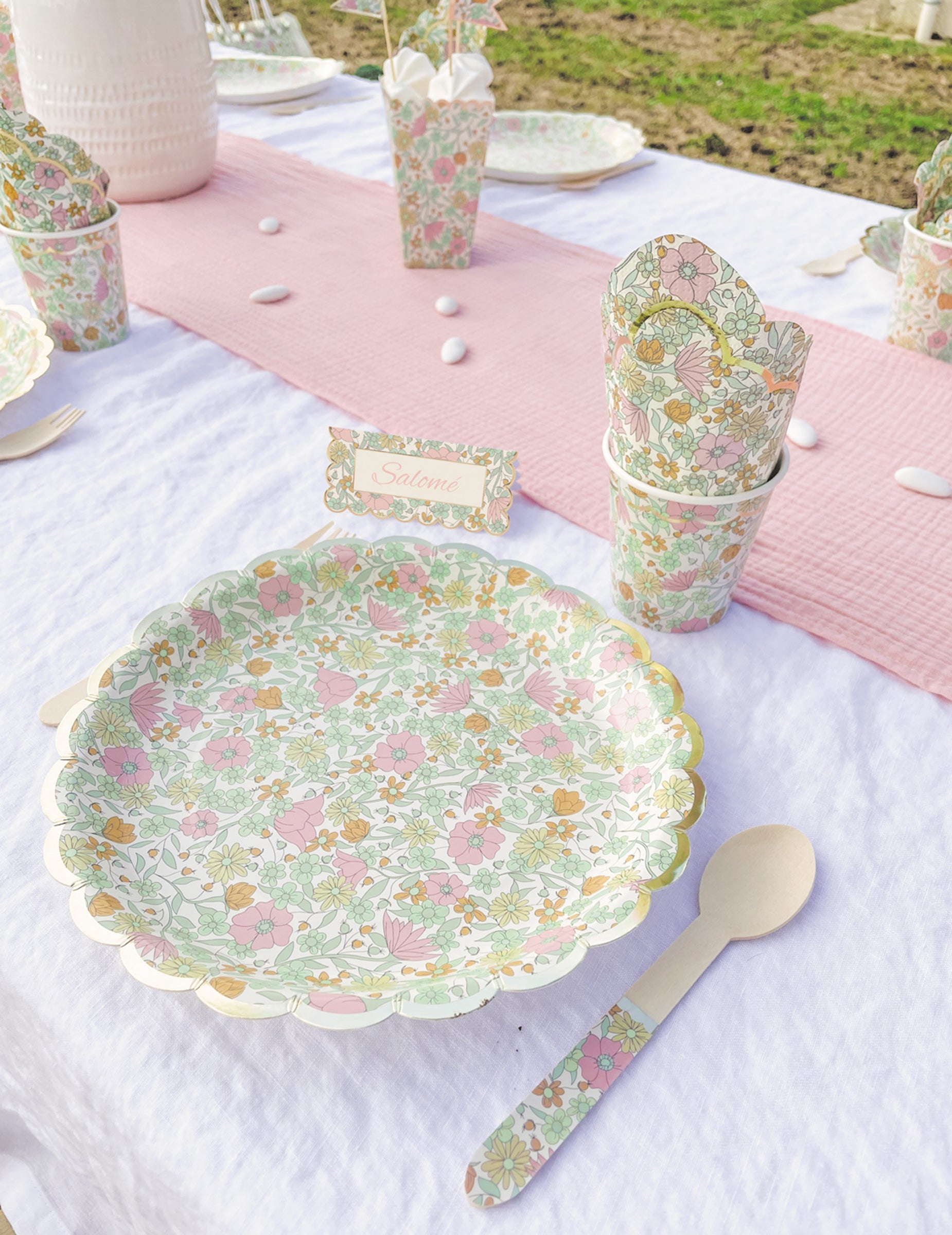 Mise en situation sur une table de fête des assiettes festonnées en carton shabby à fleurs or