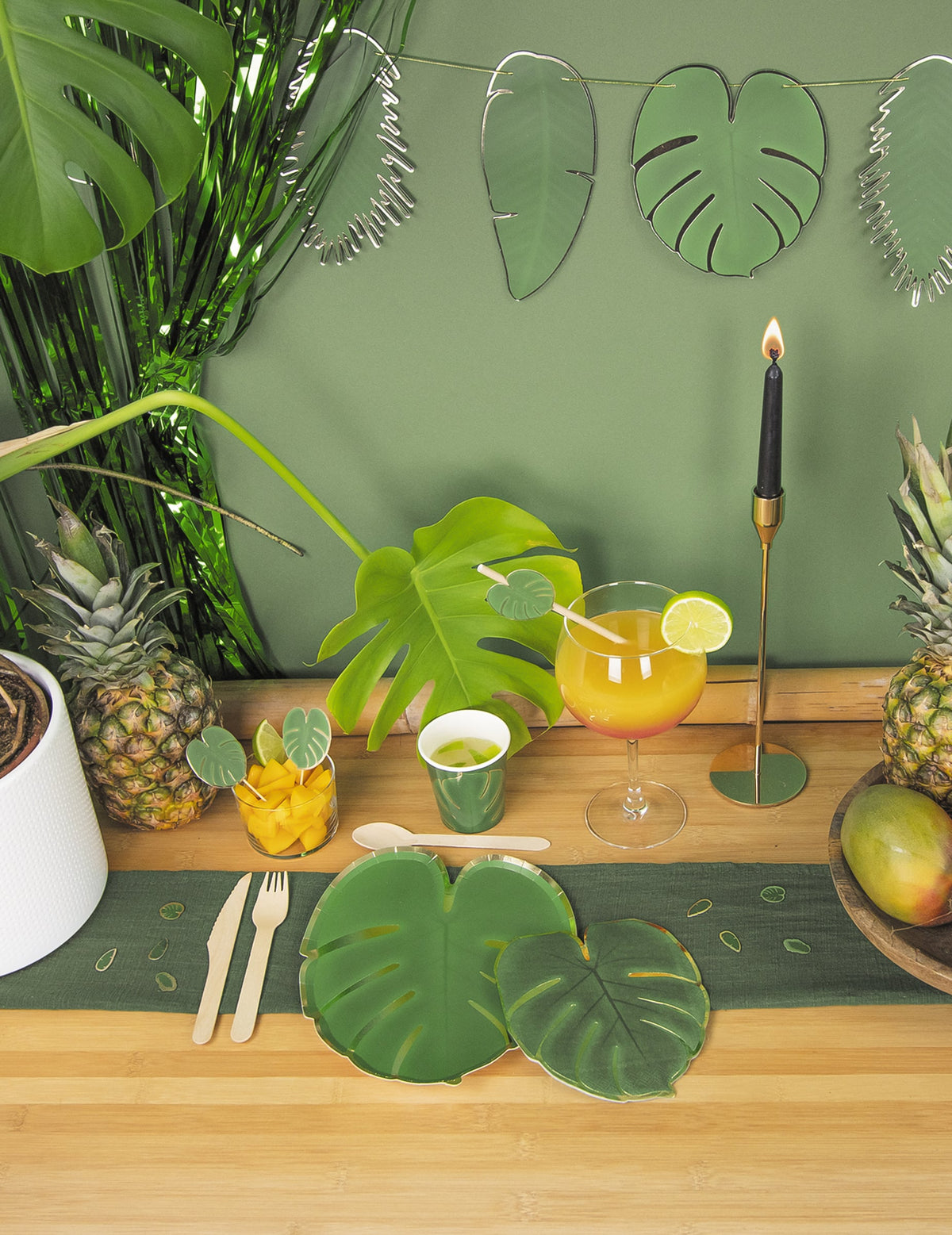 Mise en situation sur une table de fête des assiettes en carton feuille tropicale
