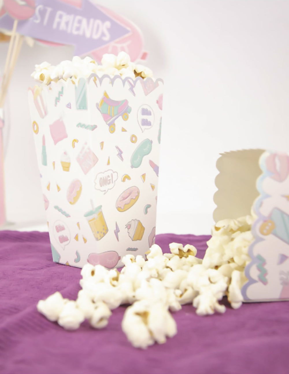 Mise en situation avec popcorn renversé de la boîte à pop corn pyjama party irisé aux motifs girly