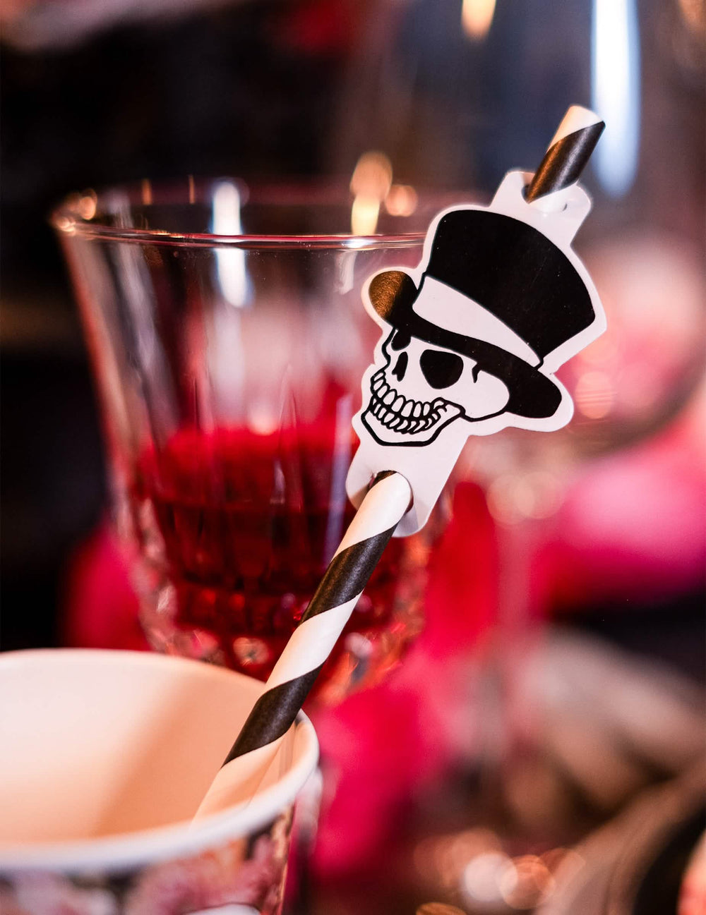 Detail na prívesok s lebkou na pruhovaných slamkách kostry halloween