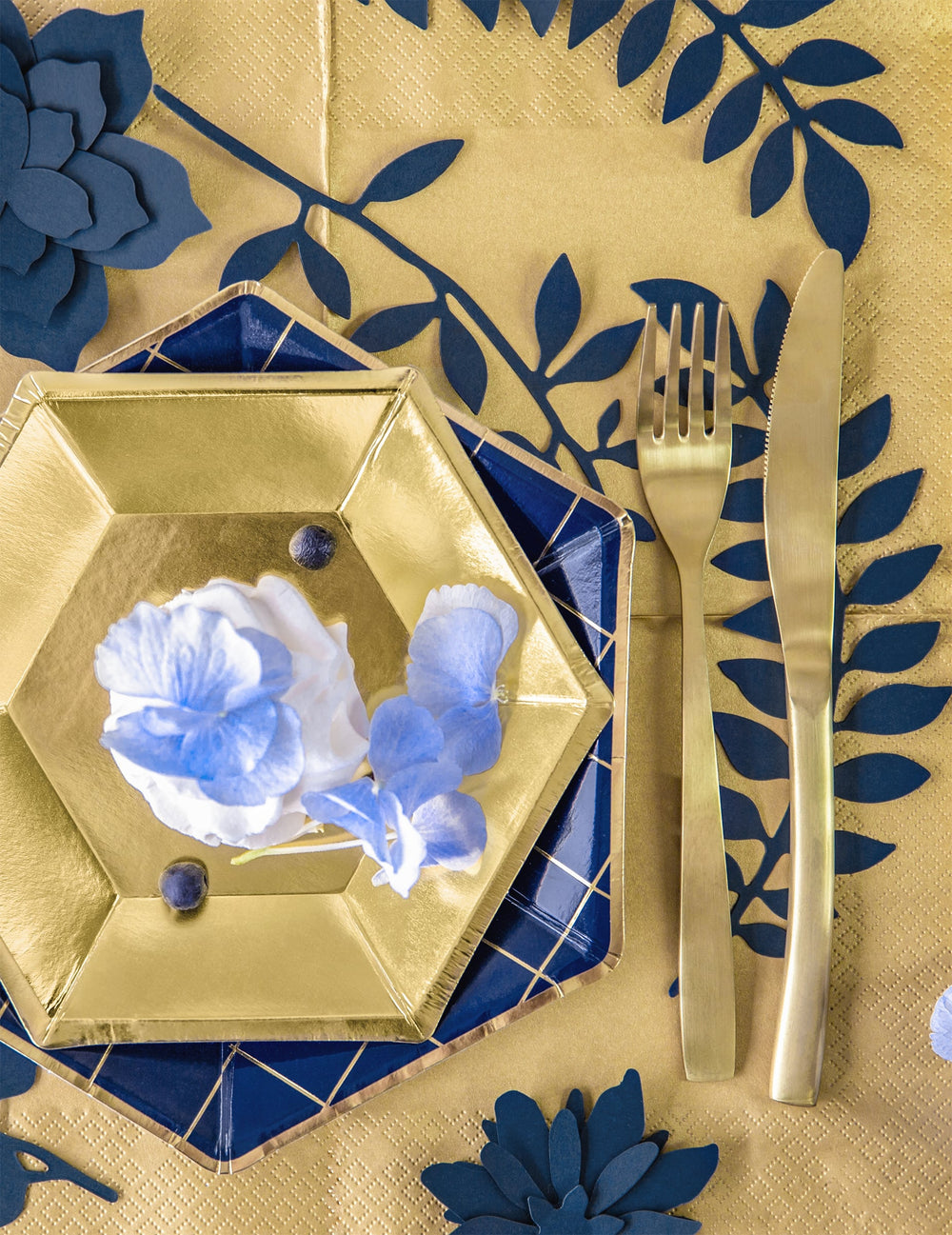 Vue de dessus d'un dressage de table avec les décorations de table feuilles pour fête bleu marine en papier