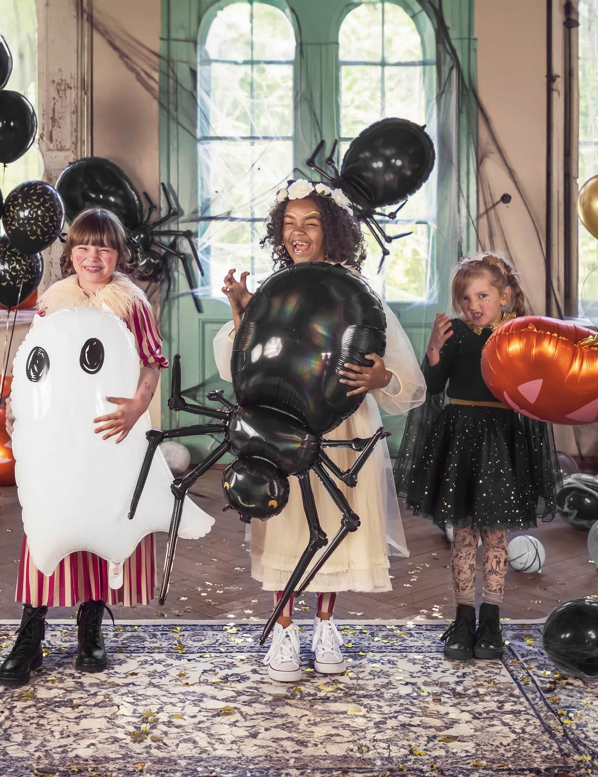 Halloweenska scéna s deťmi s hliníkovým balónom pavúka