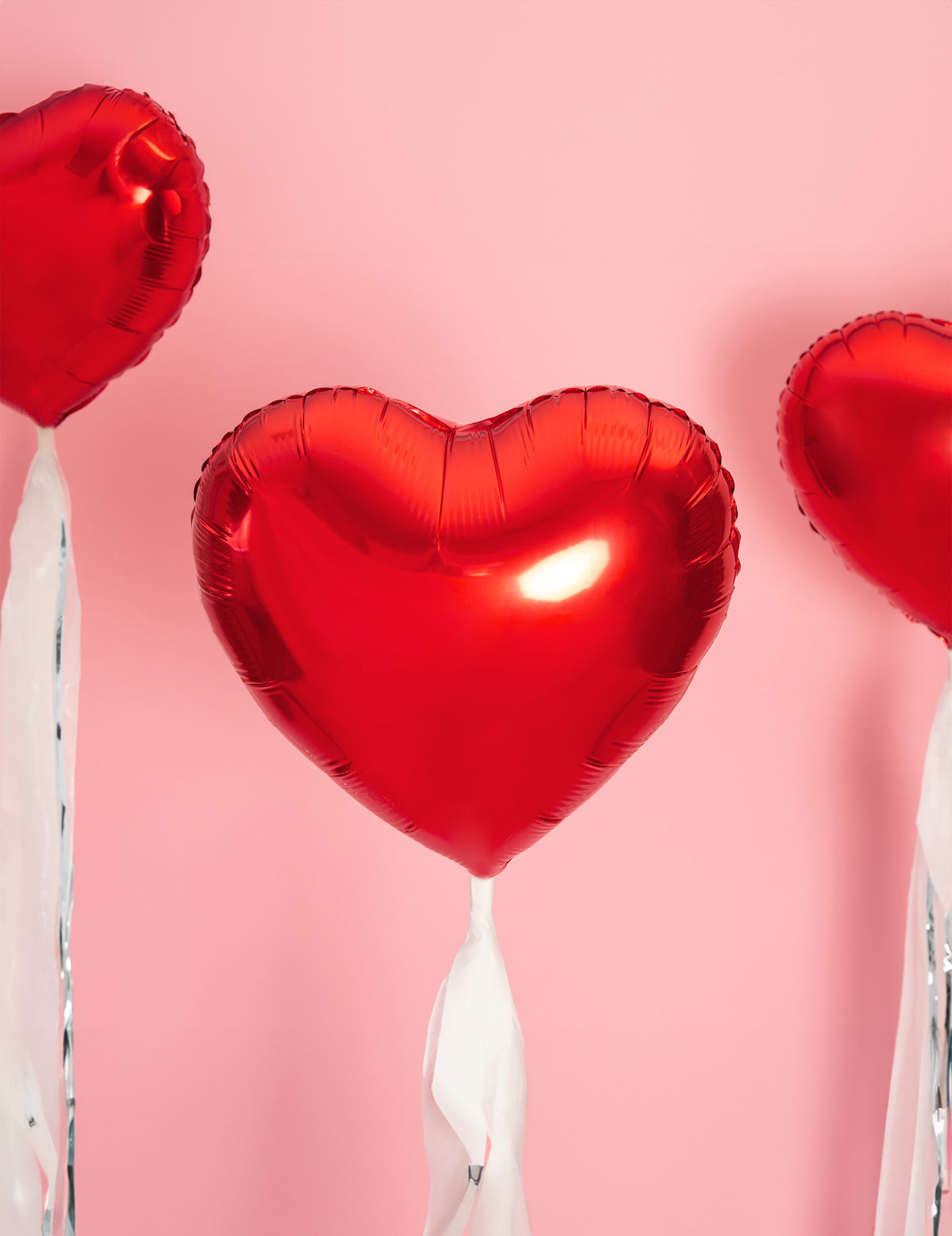 Mise en situation sur fond rose du ballon aluminium coeur pour fête rouge métallisé
