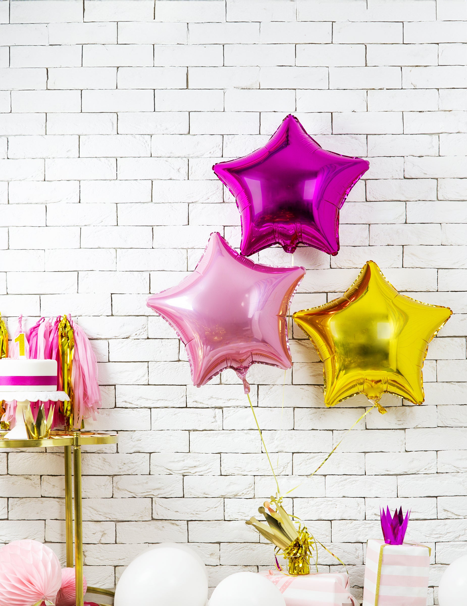 Mise en situation dans un décor d'anniversaire du ballon aluminium étoile rose pastel