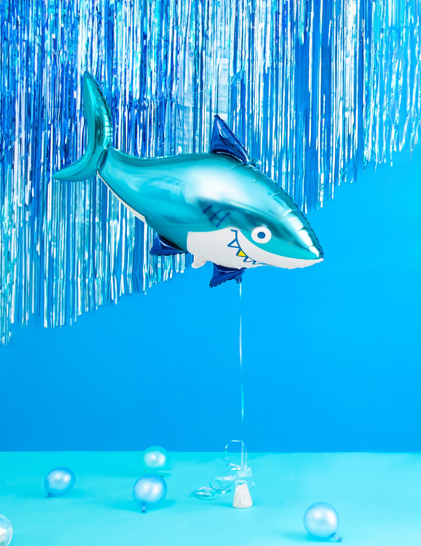 Mise en scène avec rideau bleu du ballon aluminium requin pour anniversaire océan