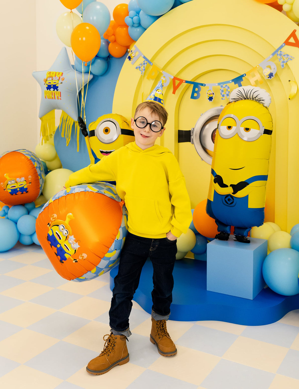 Mise en situation du ballon aluminium Tim Minions™ dans un décor d'anniversaire
