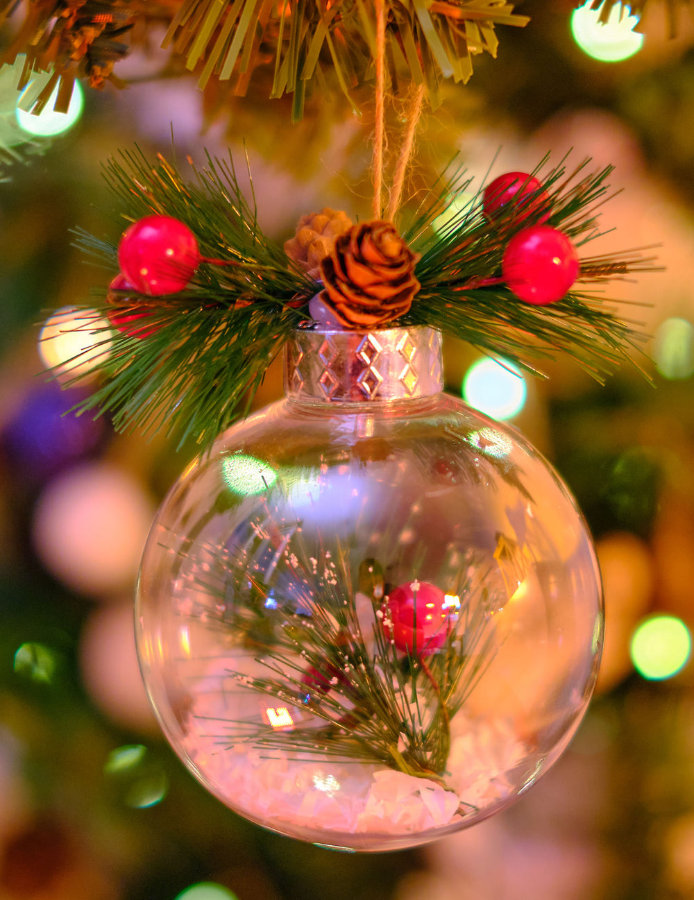 Gros plan sur la pomme de pin et les baies de la boule de Noël naturelle avec neige et sapin