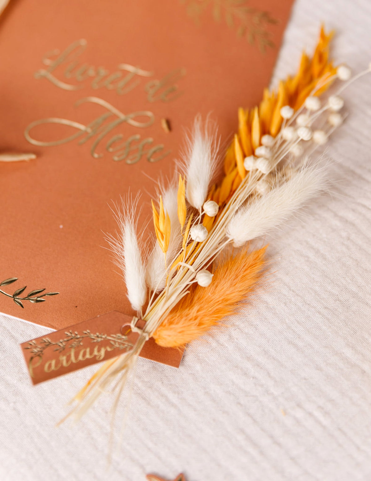 Détail de l'utilisation sur un livret de messe du bouquet de lin séché bohème