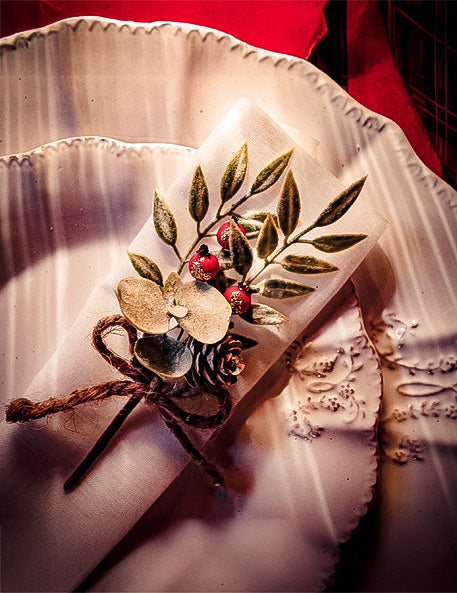 Mise en situation sur une serviette de la branche de feuilles pomme de pin et baies rouges décorative de Noël