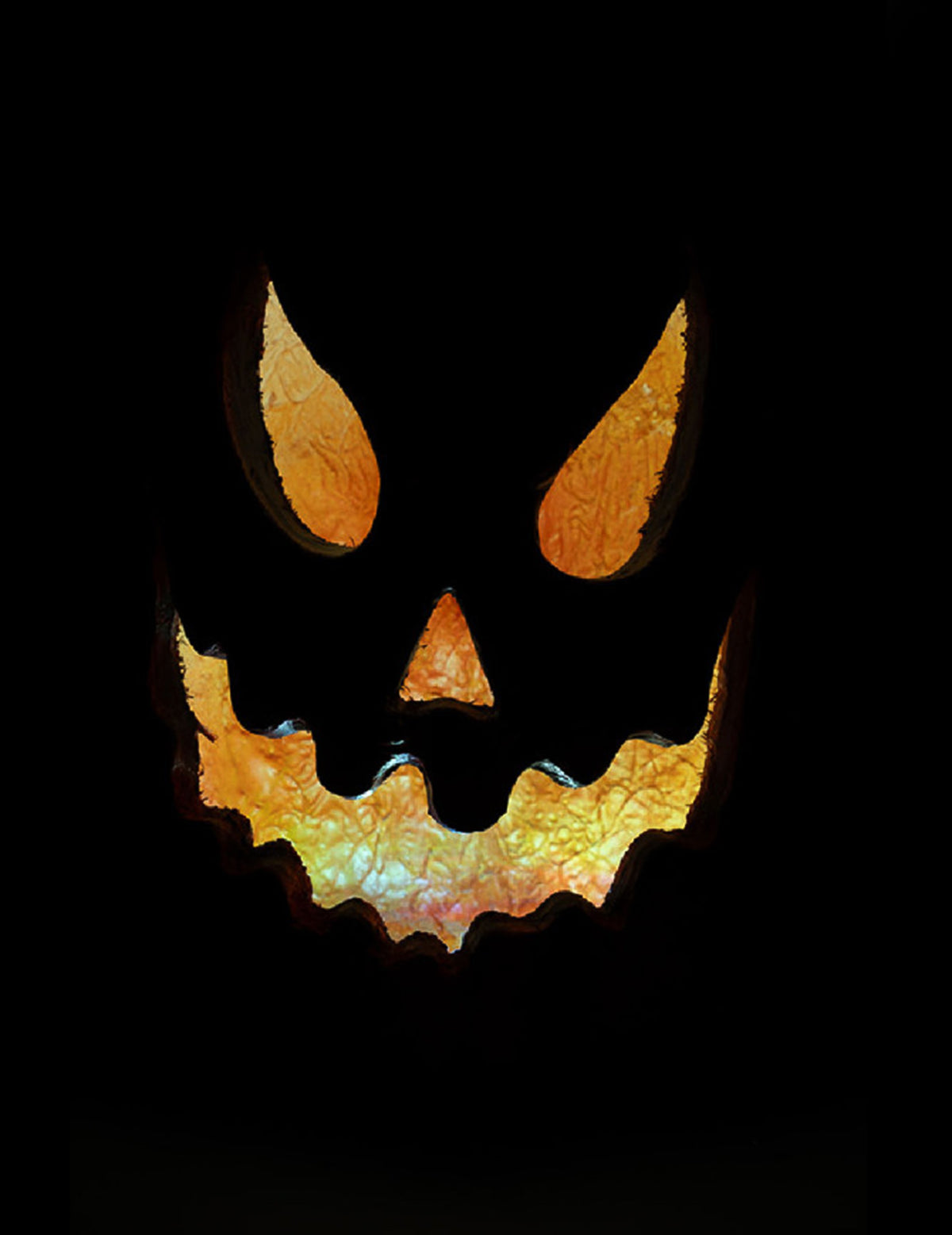 Gros plan sur le visage illuminé de la citrouille lumineuse effrayante pour Halloween
