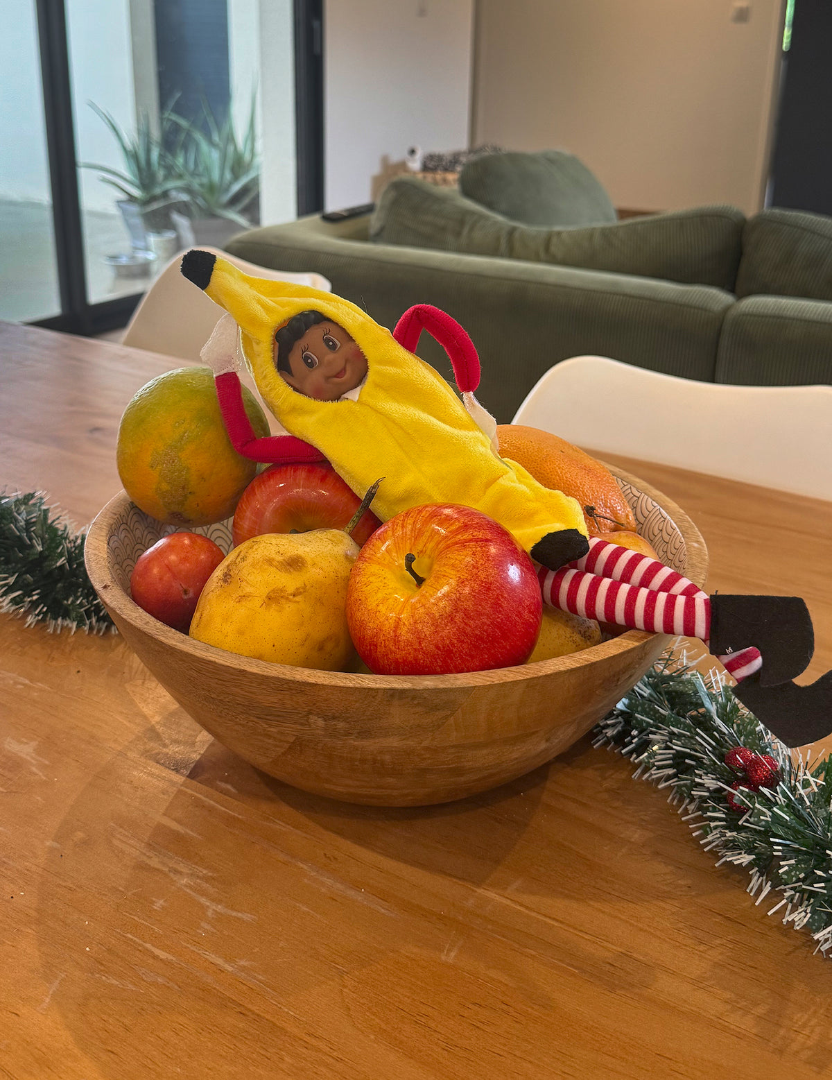Mise en scène dans une corbeille de fruits du déguisement de banane pour poupée lutin farceur
