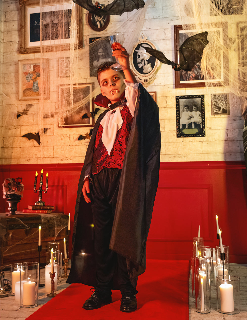 Mise en situation du déguisement vampire élégant pour garçon dans un décor d'Halloween